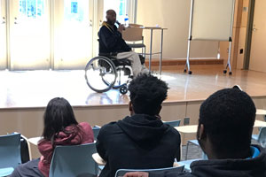 Man in wheelchair speaking to students