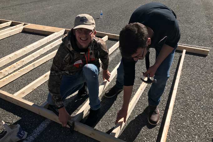 Heritage CTE student framing house wall