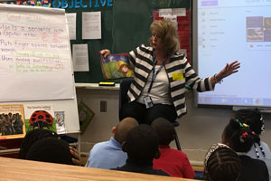 Woman reading book to kids sitting in floor