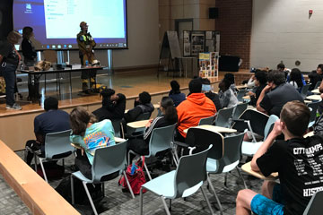 Heritage students seated in the Forum during cave expert presentation