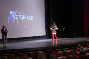 Presenter on stage with "Choose Positive Influences" slide in background