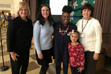 Four women and a child smiling