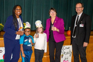 Administrators and students pose with Virginia Secretary of Agriculture Betina Ring while holding glasses of milk