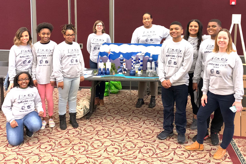 Students and teachers standing in front of future city model