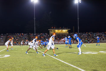 Football players on field during game at night