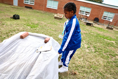 Student working outside preparing school gardfen