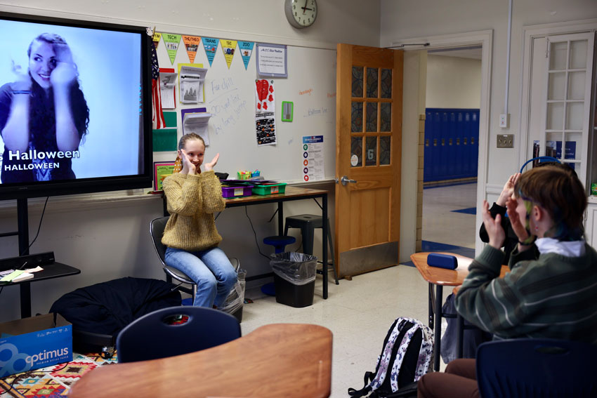 Student leads her peers in an ASL interpretation of song