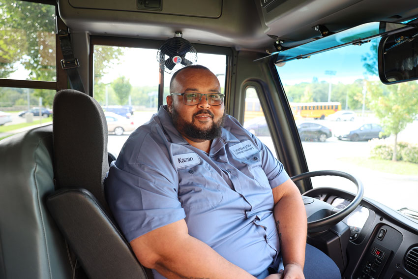 Kazan Johnson sitting behind wheel of new electric bus