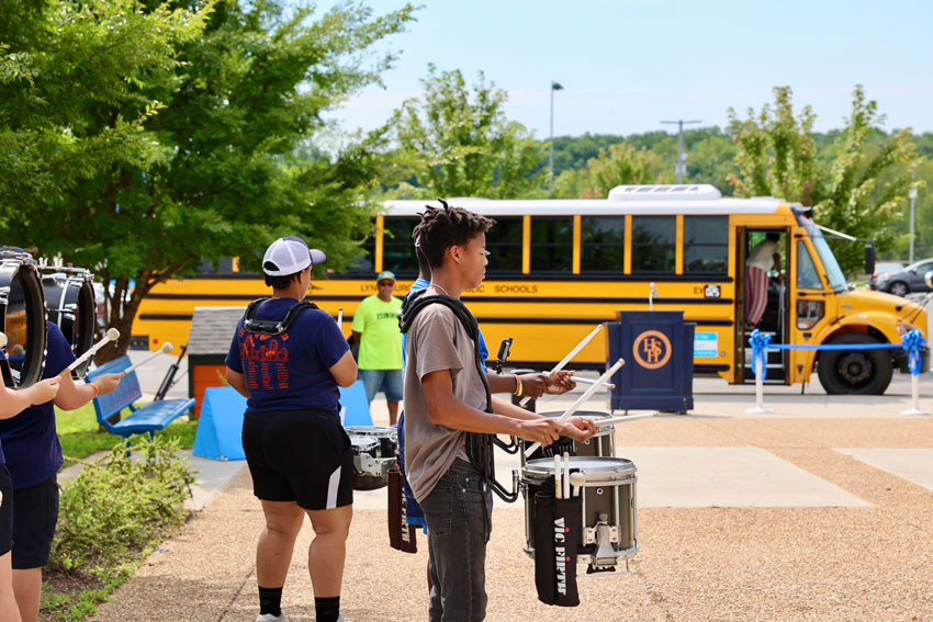 Marching band members play music before EV bus ribbon cutting ceremony