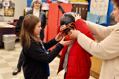 Student putting on helmet with camera mounted on top