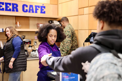 Student handing change to cafe customer