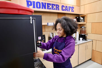 Student pouring coffee in Pioneer Café