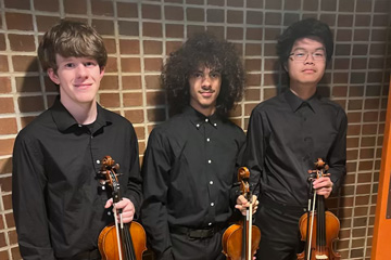 Isaac Hardin, Thomas Lamb, and Calvin Guo holding violins