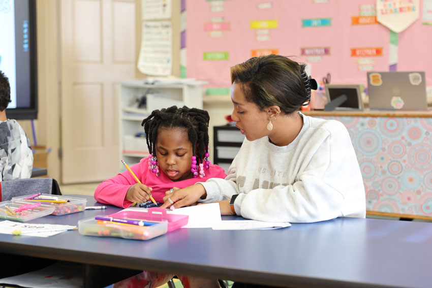 Teacher working with student at table