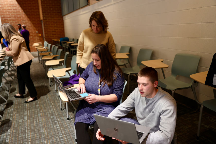 Educators with laptops working together