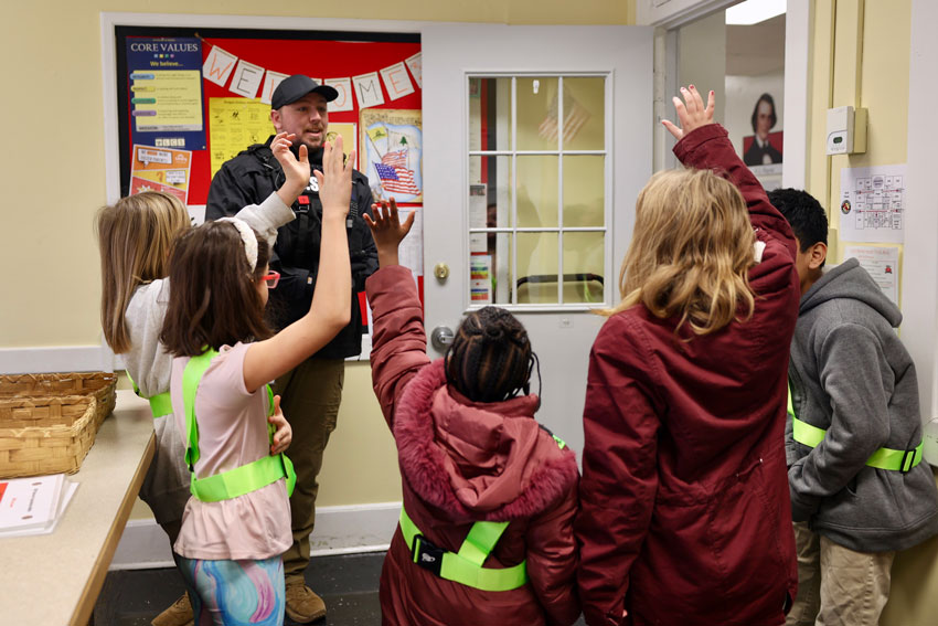 SSO speaking in main office while students raise hands 