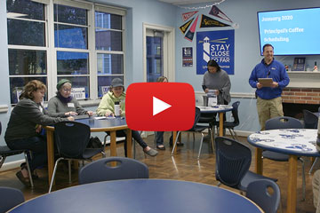 Video screenshot of principal speaking to group