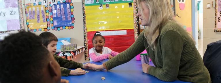 Teacher at table with students